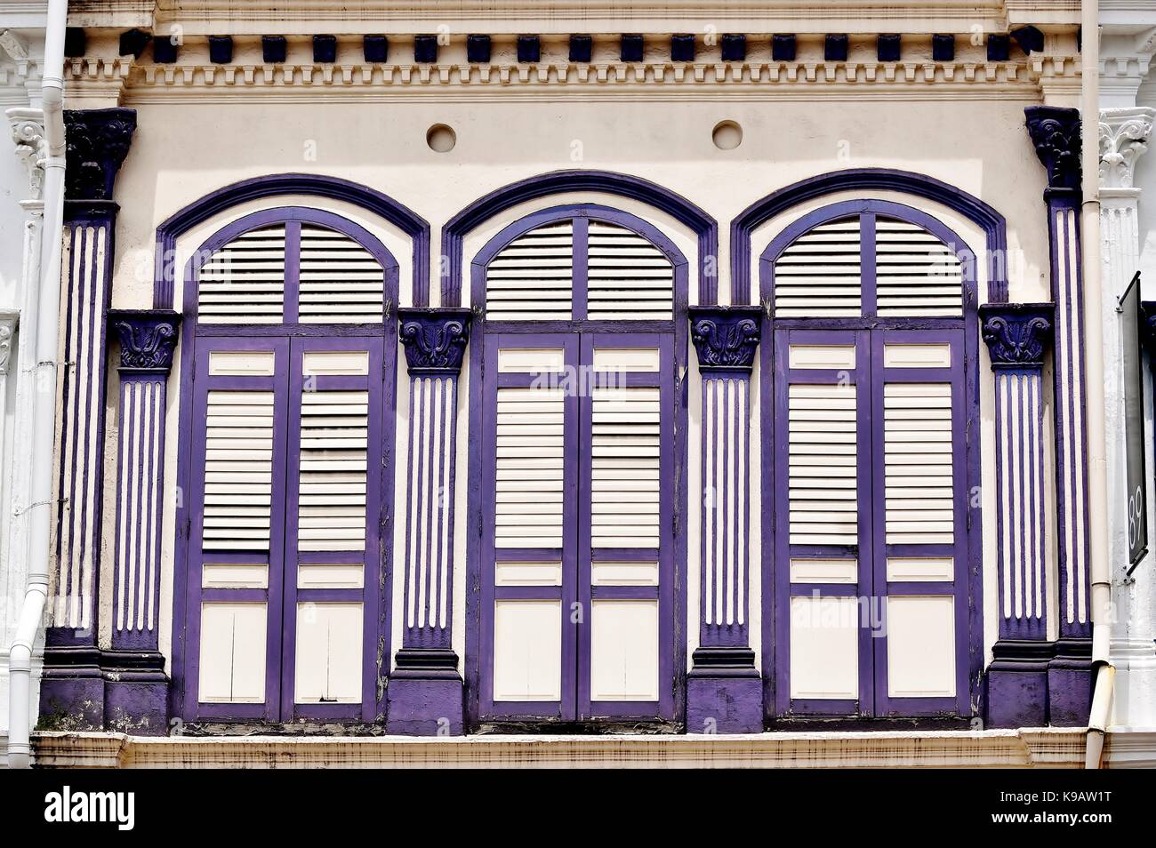 Tienda de Singapur tradicional exterior de la casa con ventanas arqueadas y púrpura y persianas con tablillas de madera blanca en el Duxton distrito histórico. Foto de stock