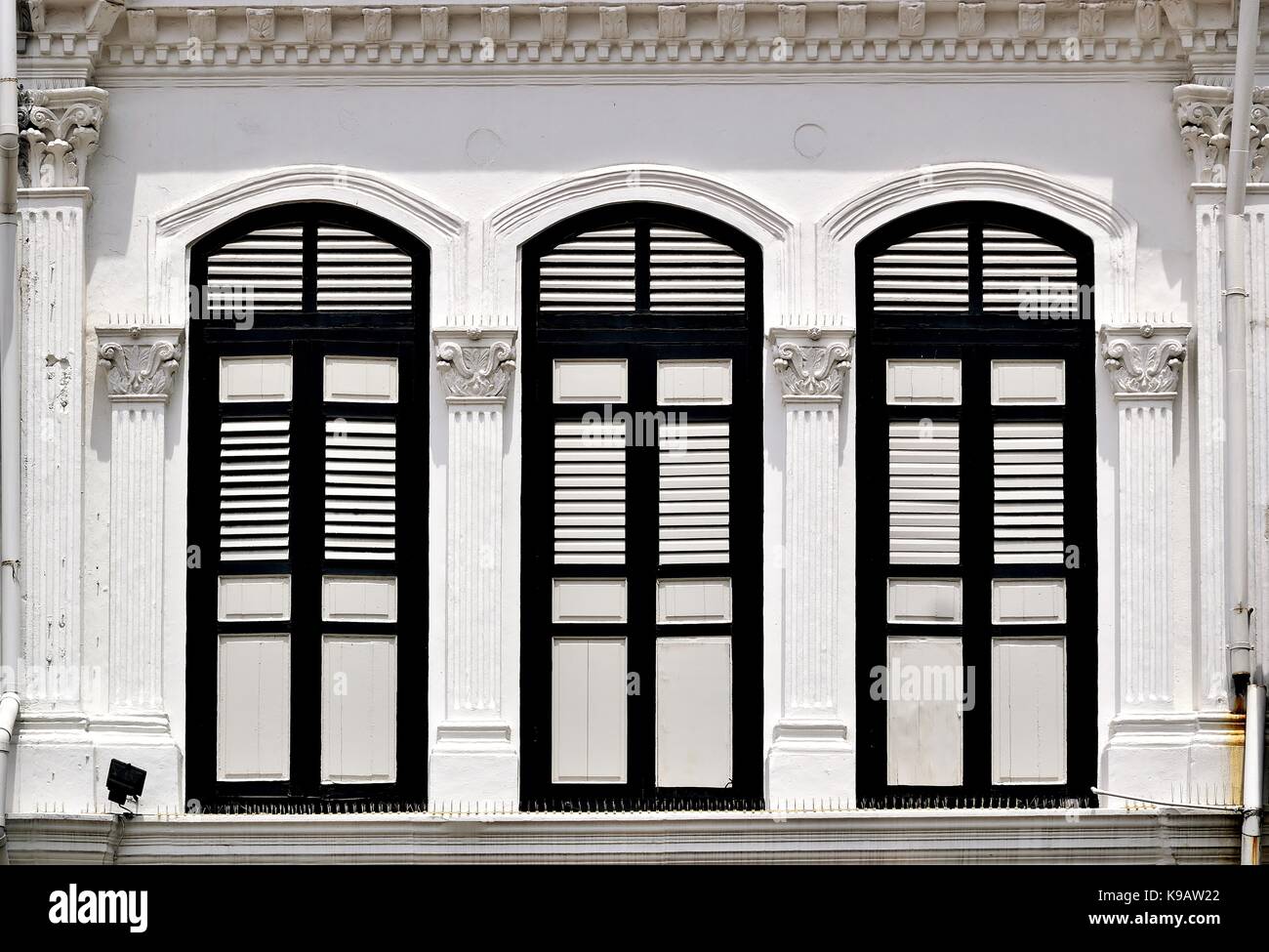Tienda de Singapur tradicional exterior de la casa con ventanas arqueadas, persianas con tablillas de madera blanca y columnas corintias en el histórico duxton zona. Foto de stock
