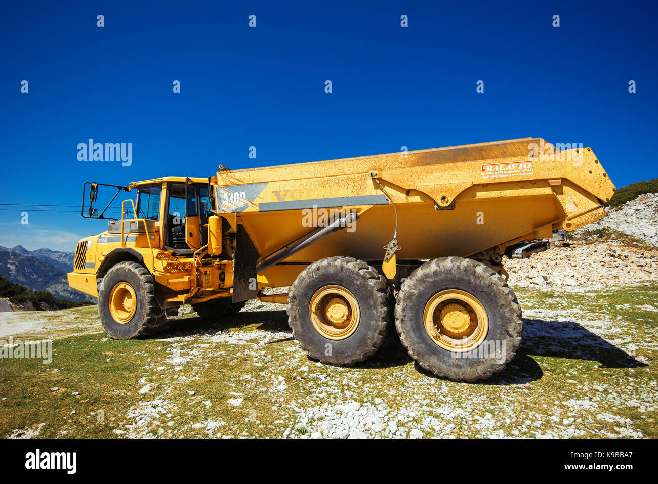 Vogel montaña, Eslovenia - Agosto 30, 2017: Maquinaria de construcción para la trituración de piedra, grandes camiones volvo dumper trabajando en ladera de montaña Foto de stock