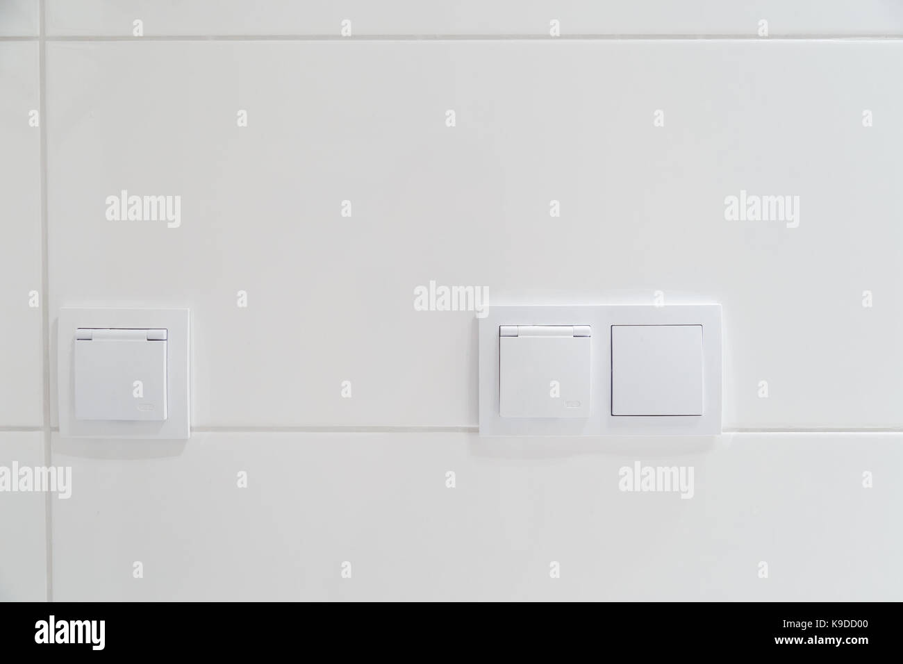 Interruptores eléctricos modernos en una pared blanca de azulejos  Fotografía de stock - Alamy