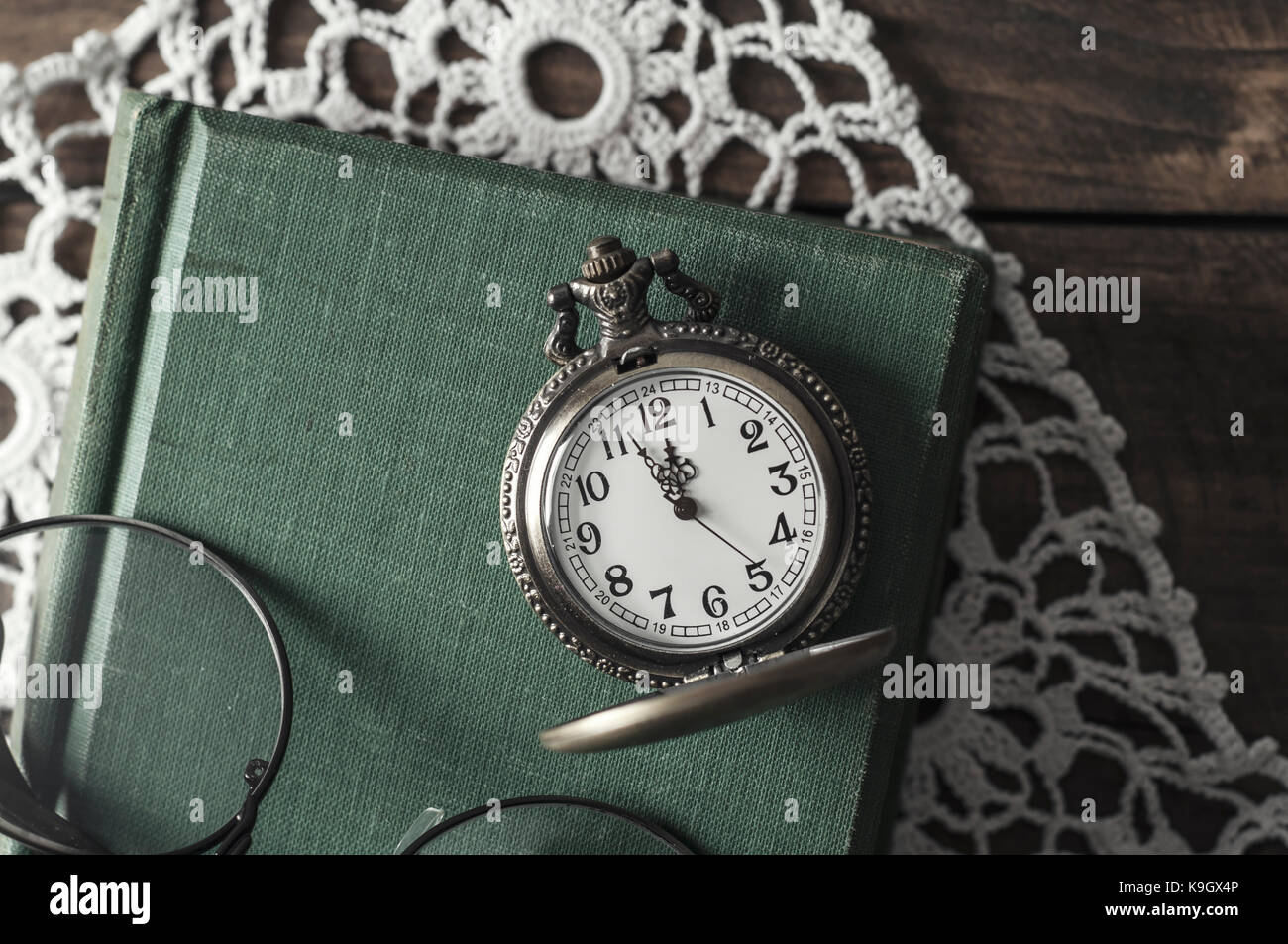 Un antiguo reloj de bolsillo, gafas y libros sobre la mesa Fotografía de  stock - Alamy