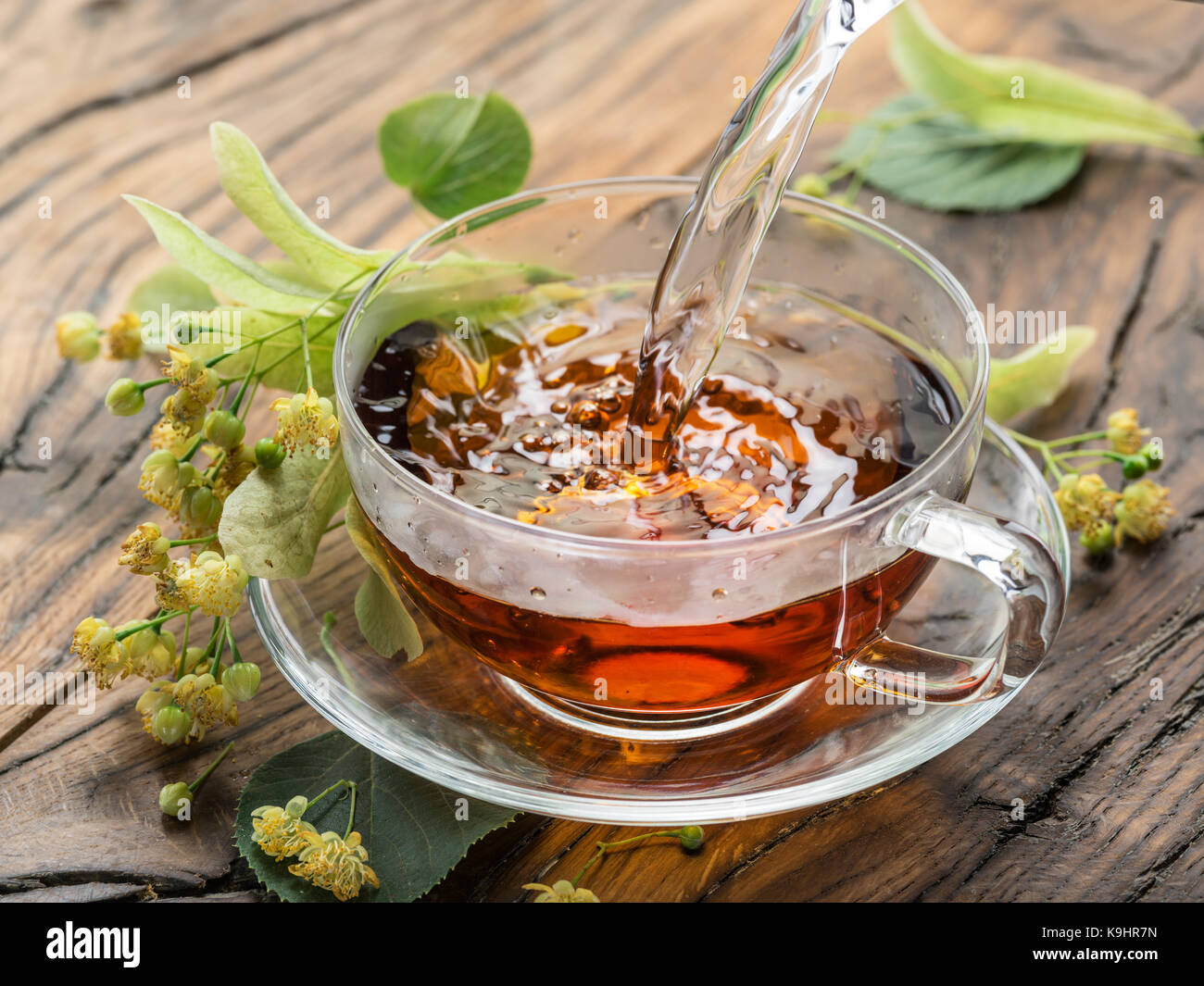 Taza de Té de Tilo y Limón, flores en la mesa de madera Fotografía de stock  - Alamy