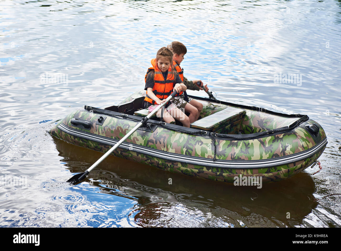 Los niños de chalecos salvavidas nadar en el barco Foto de stock
