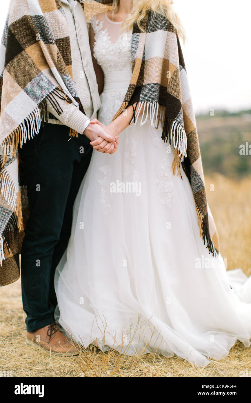 El matrimonio, naturaleza, relaciones concepto. novio y novia vestidos de  traje y vestido de boda nos abrazamos permanente y cubiertos por la calida  y confortable el Plaid con crema de plazas Fotografía