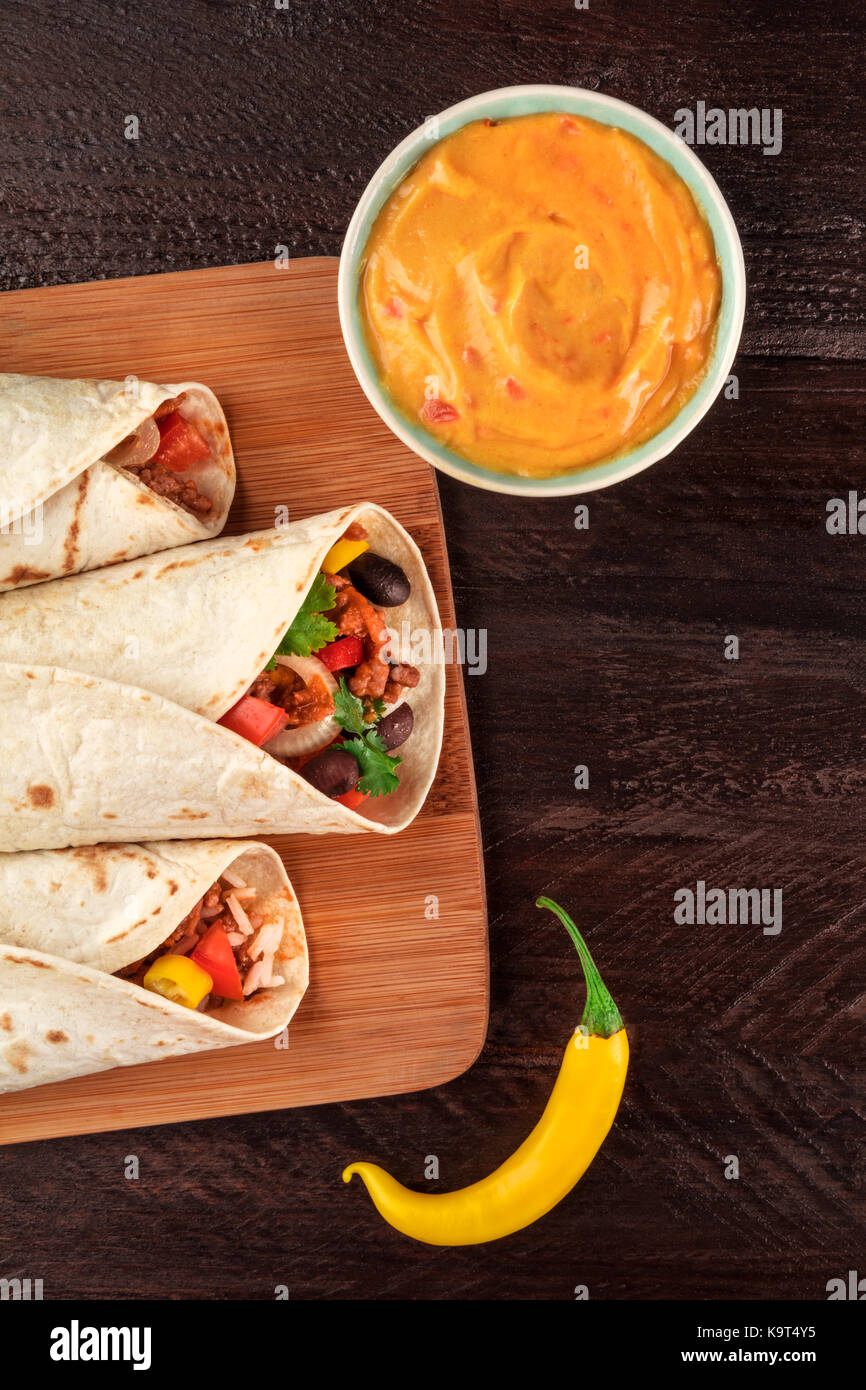 Burritos mexicanos con salsa de queso, pimientos y copyspace Fotografía