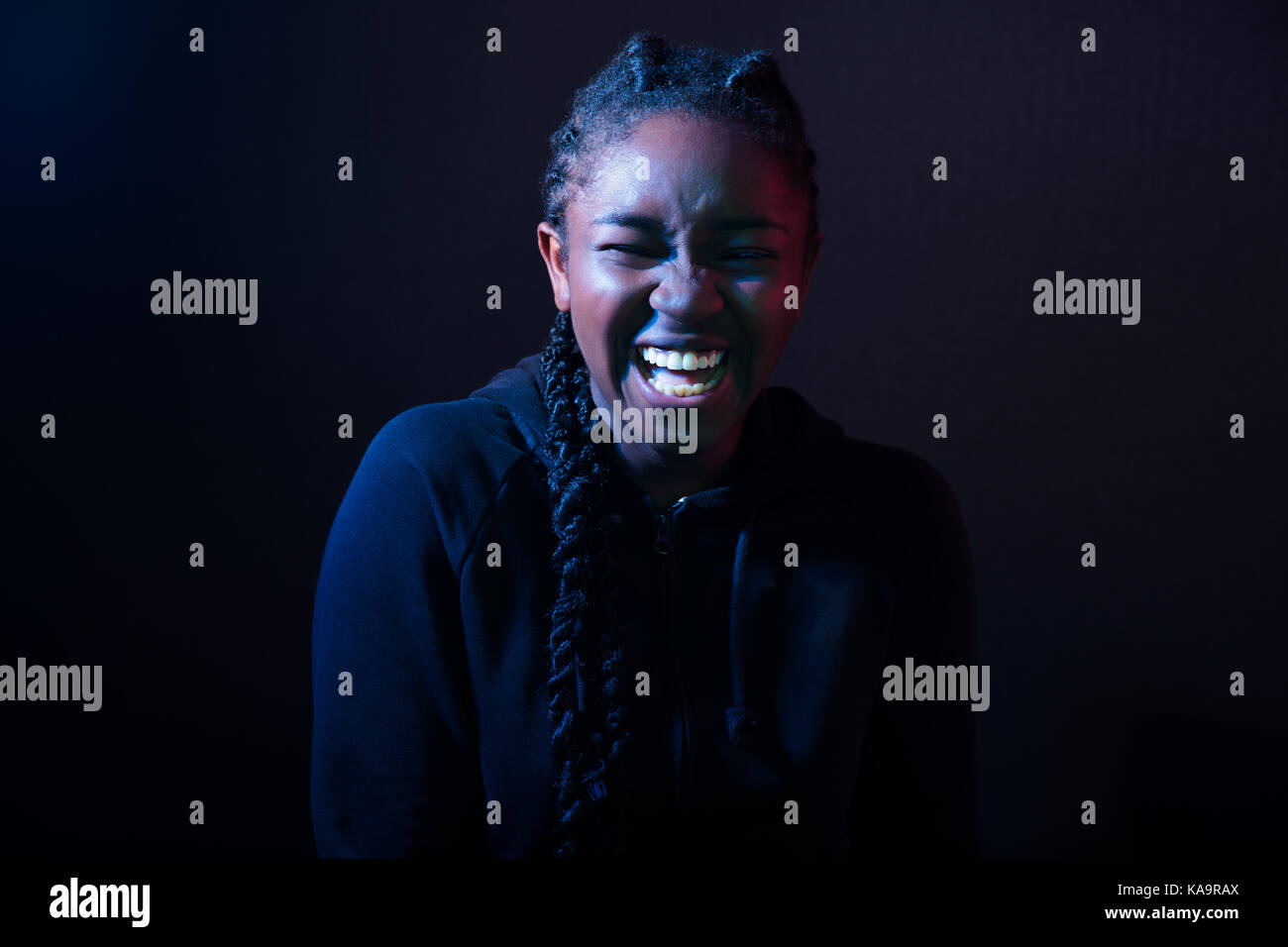 Mujer riendo sobre fondo negro Foto de stock