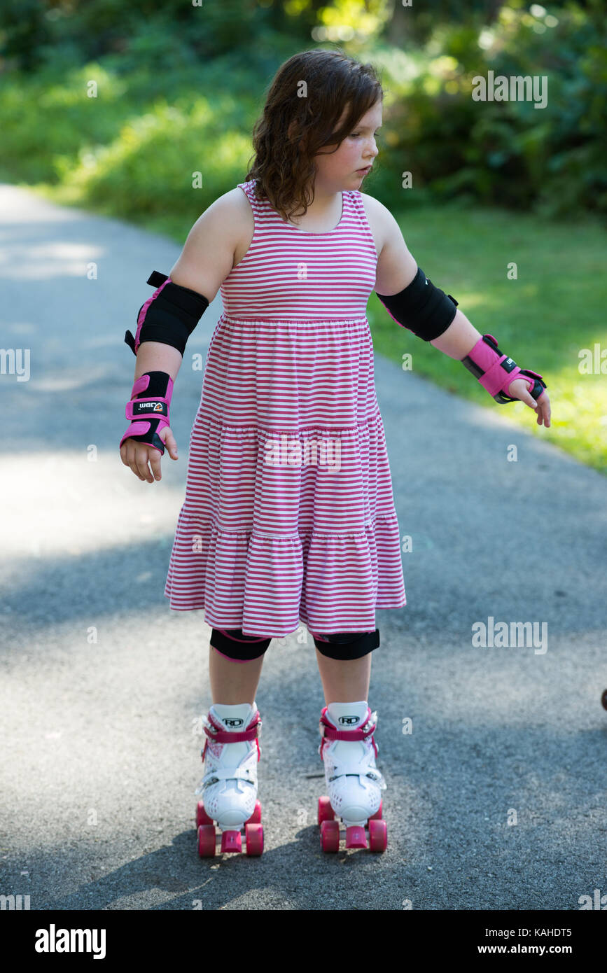 Niña fuera aprendiendo a caballo sobre patines en camino usando protectores de muñeca, codo y rodilleras Fotografía de stock Alamy
