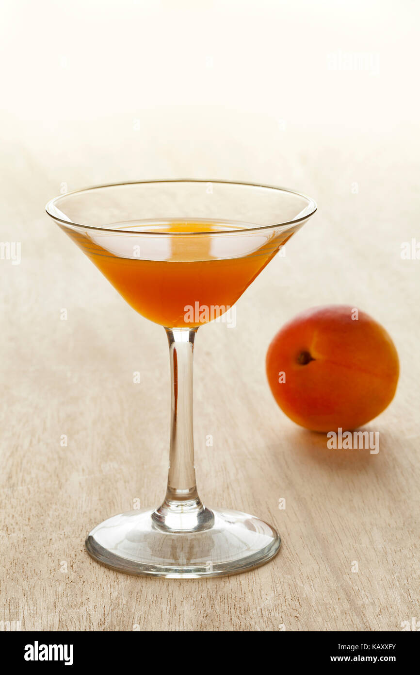 Copa de licor de albaricoque y fruta fresca en el fondo Foto de stock