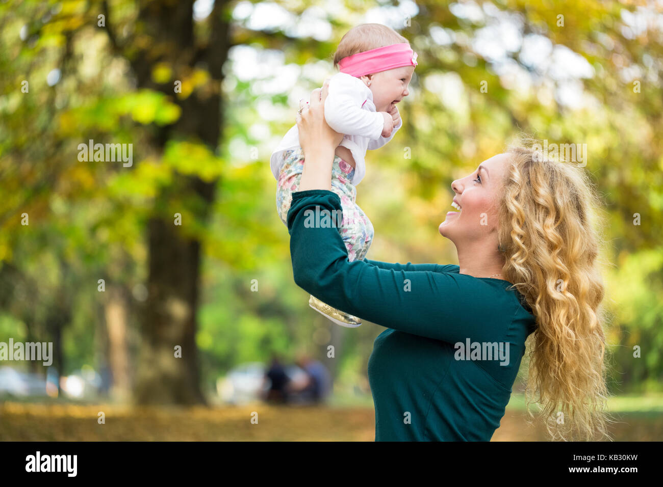 Joven mamá con su bebé en el parque, felices juntos Foto de stock