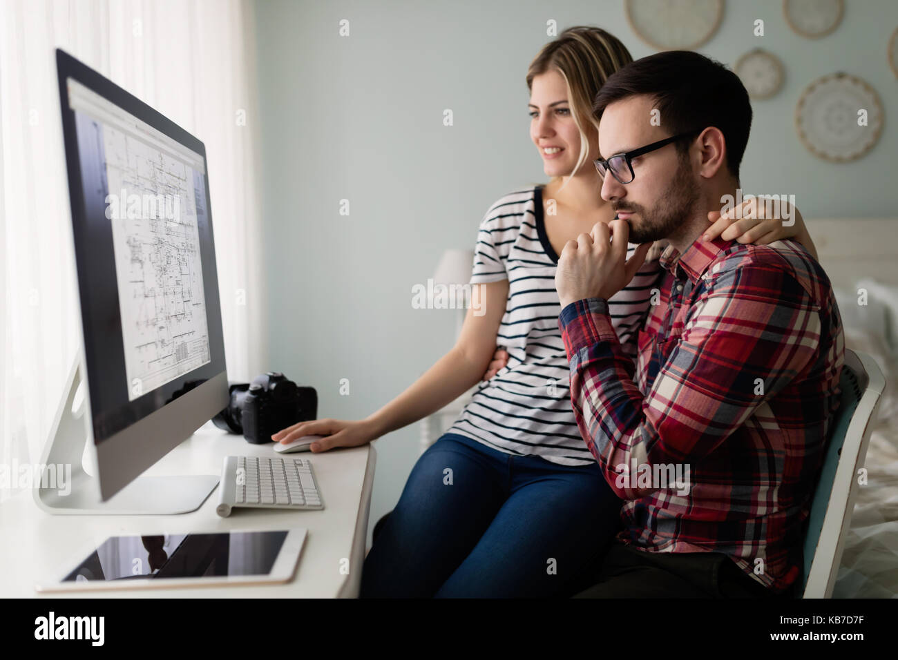 Atractivas jóvenes diseñadores que trabajan juntos desde casa Foto de stock