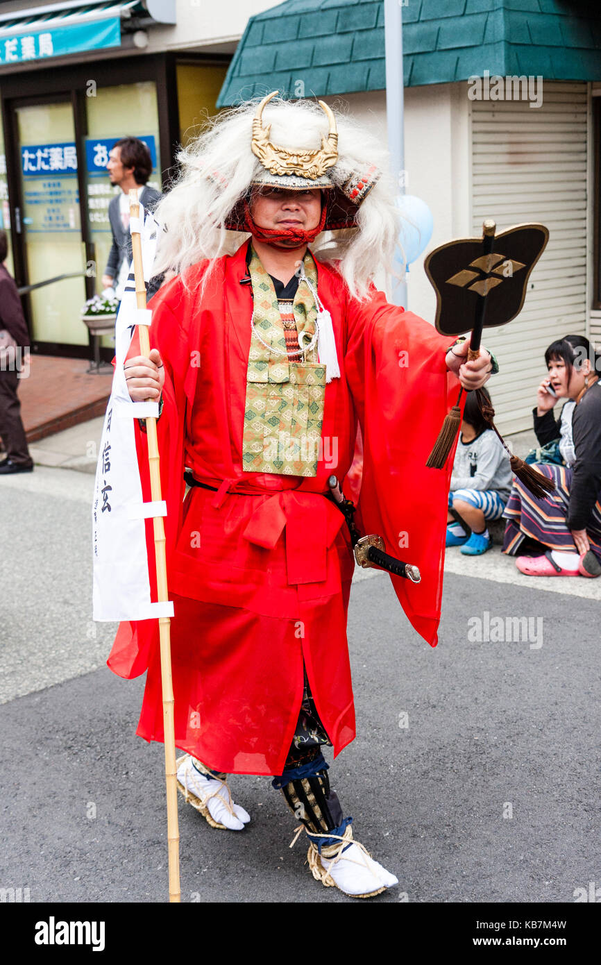 Genji desfile anual en Tada, Japón. Samurai Warrior con abrigo rojo y larga cabellera blanca colgando del yelmo crestado, caminando por la calle. Foto de stock