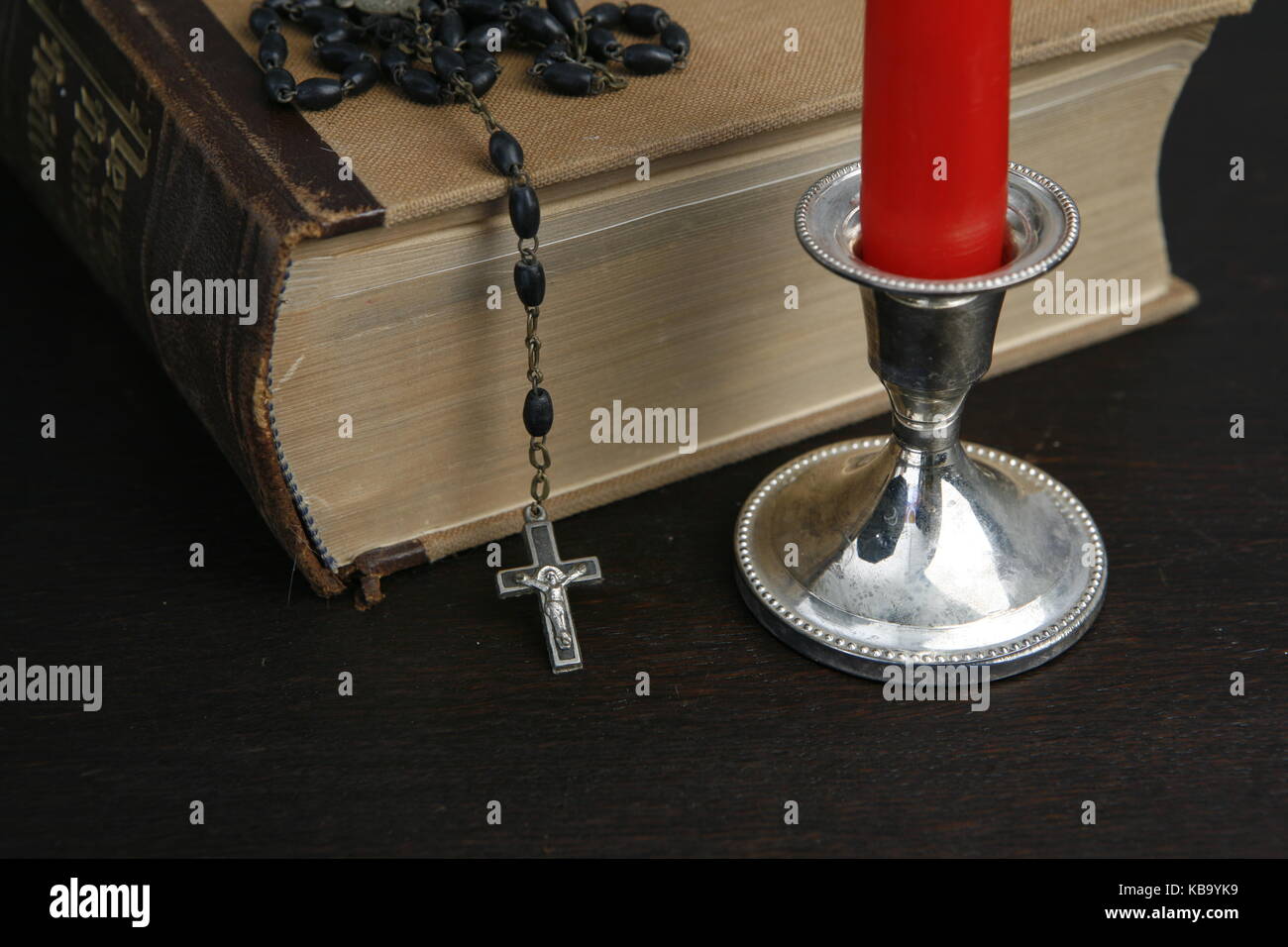 Kerze mit Bibel und Rosenkranz und Buch - Candle con Biblia y Rosario y Libro Foto de stock