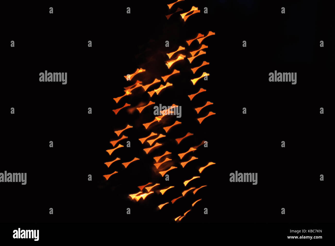 Resumen cerca de forma de mariposa bokeh de navidad luces naranjas helios 44-2 tomadas con lentes vintage durante la noche Foto de stock