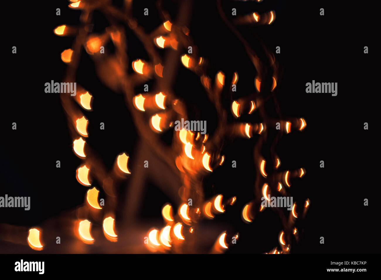 Resumen cerca de forma impar bokeh de navidad luces naranjas helios 44-2 tomadas con lentes vintage durante la noche Foto de stock