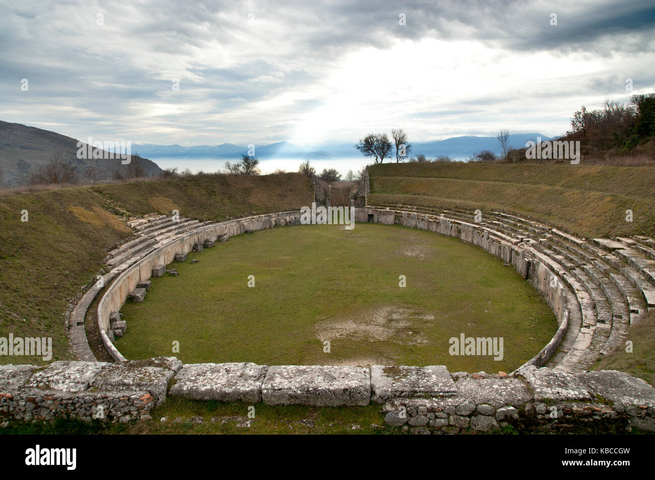 Vista del antiguo anfiteatro romano en Alba Fucens, Italia, que data de la primera mitad del siglo I DC, con fucino plateau en el fondo Foto de stock