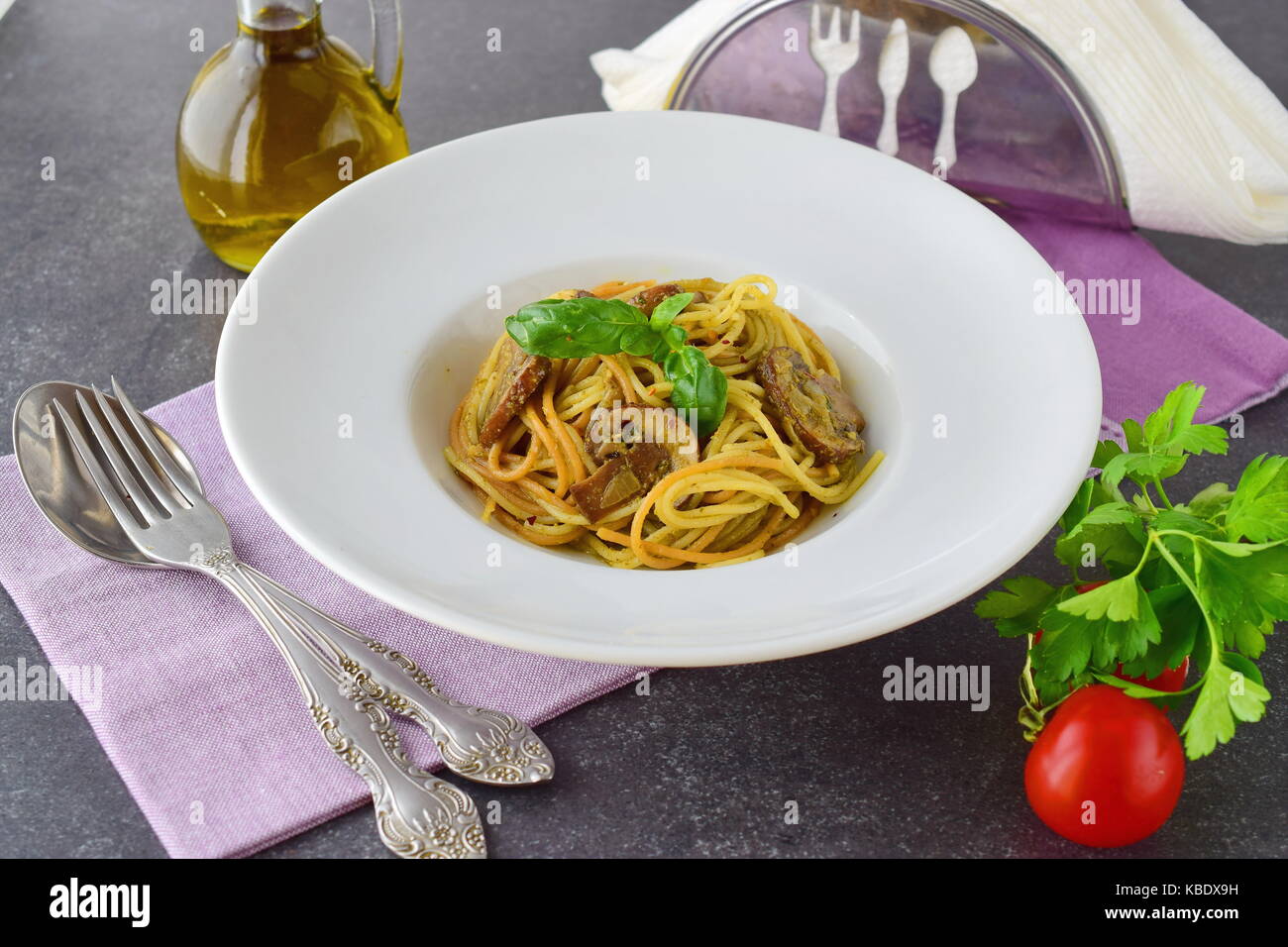 Pasta con champiñones y salsa pesto en una placa blanca sobre fondo abstracto. Estilo de vida italiano. Comer sano concepto Foto de stock