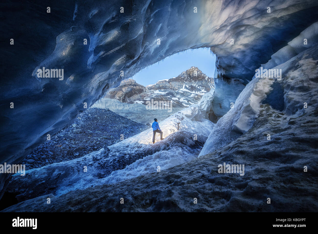 Fotógrafo en el interior de una cueva de hielo durante una expedición de fotografía en el Glaciar Athabasca Foto de stock