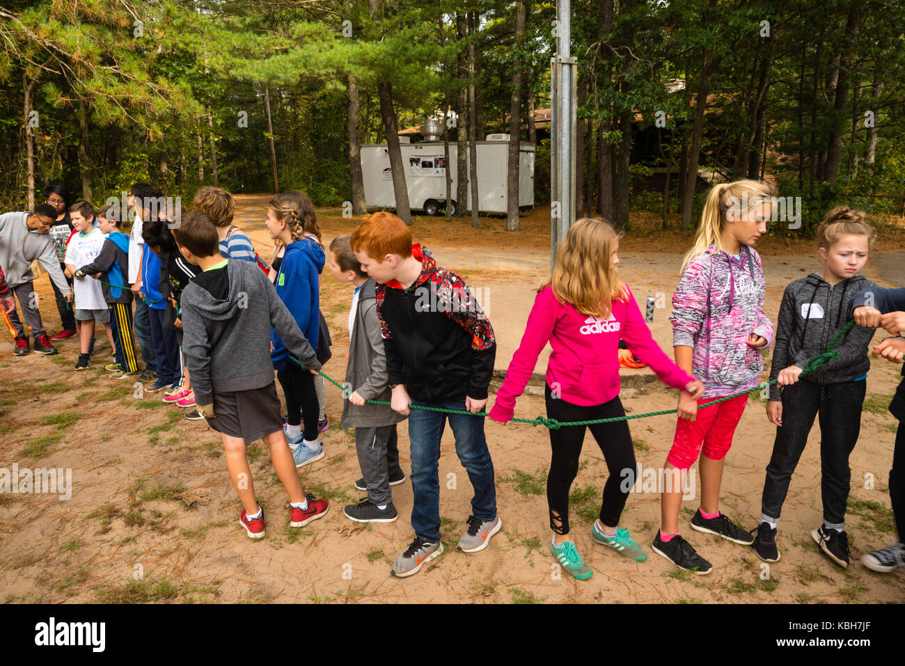 Los niños utilizan una cuerda para aprender habilidades de team building y  otras actividades de educación ambiental en upham woods centro de  aprendizaje al aire libre, una parte de la unive Fotografía