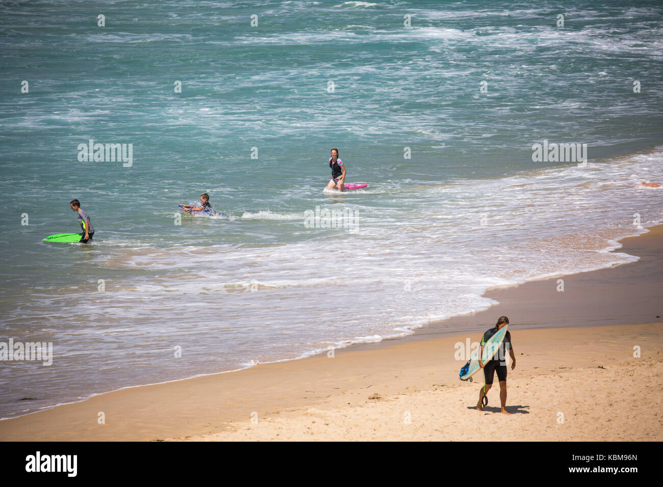Los surfistas en una milla de playa cerca de Forster en la costa de Nueva Gales del Sur, Australia Foto de stock