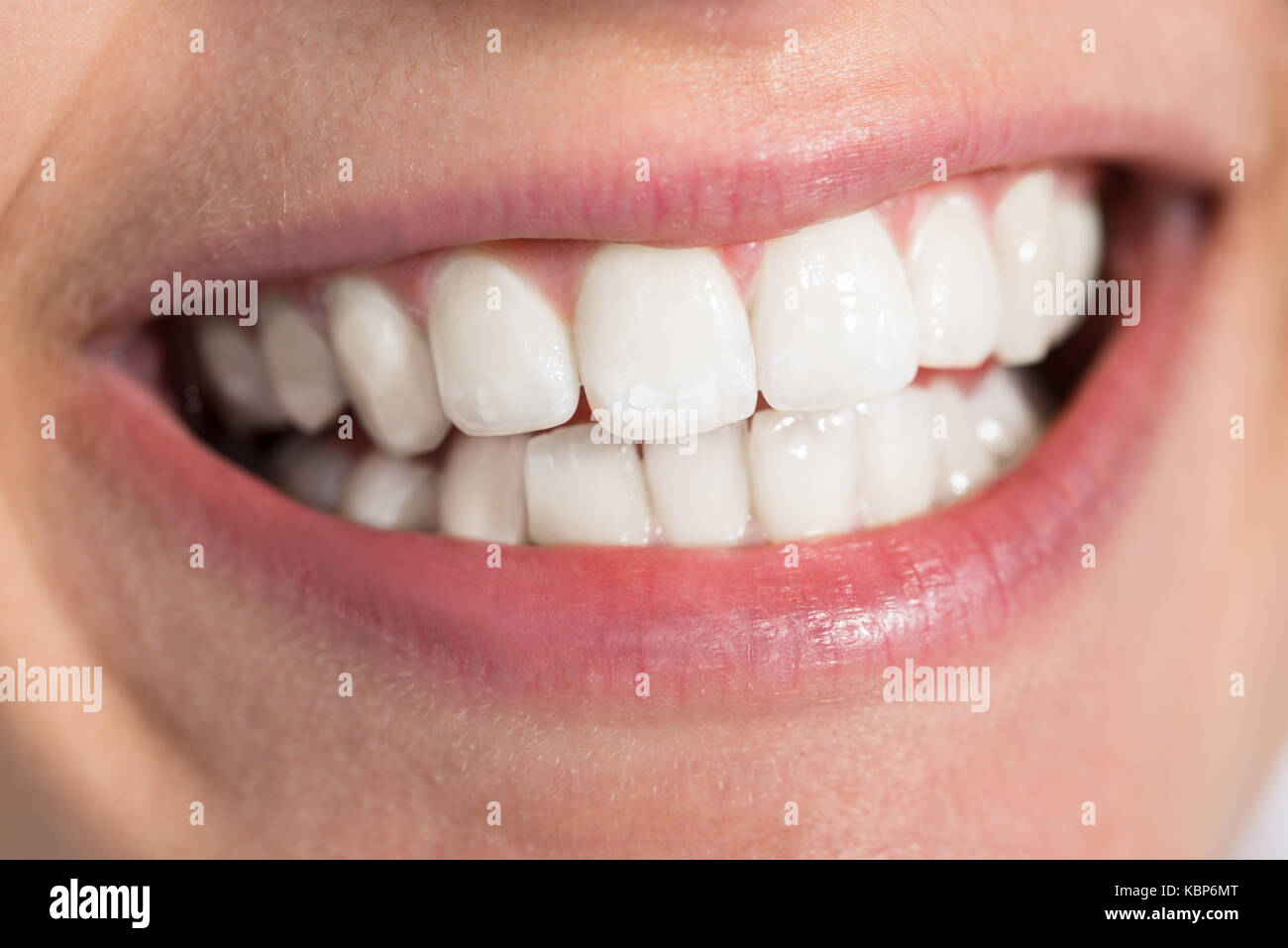 Primer plano de una mujer sonriente mostrando saludables dientes blancos Foto de stock