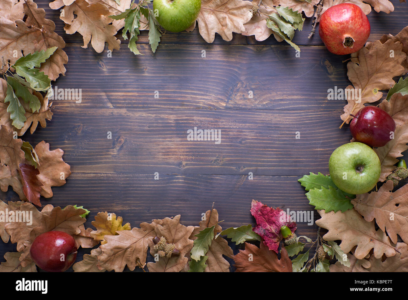 Antecedentes de otoño con hojas, manzanas y granadas.frame de la cosecha de otoño en madera envejecida con copia espacio. El boceto para la temporada de vacaciones y ofrece post Foto de stock