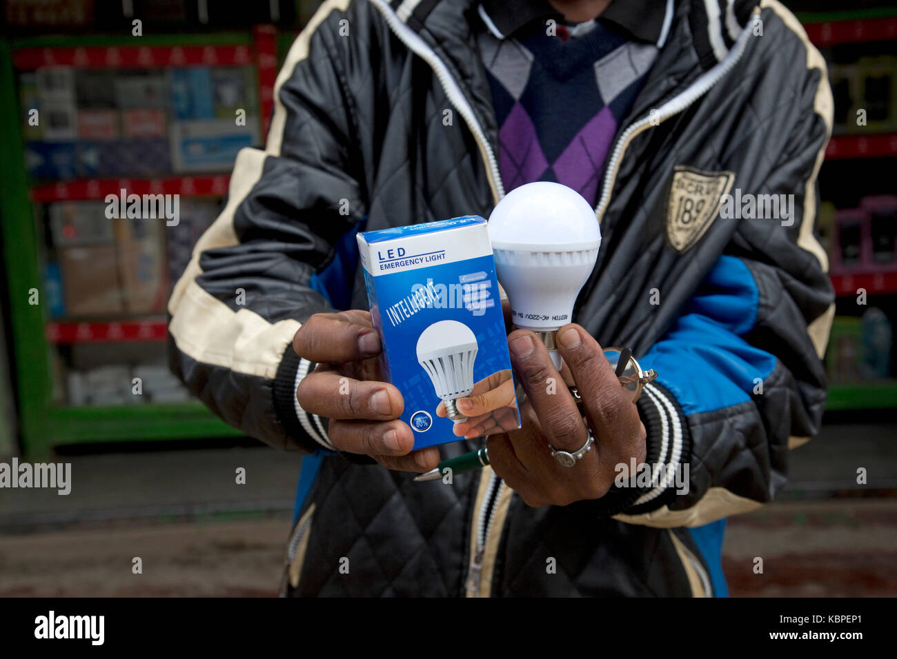 Hombre africano la celebración de Intelligent Energy effiicient lámparas LED fuera duka en kamere township Kenya Foto de stock