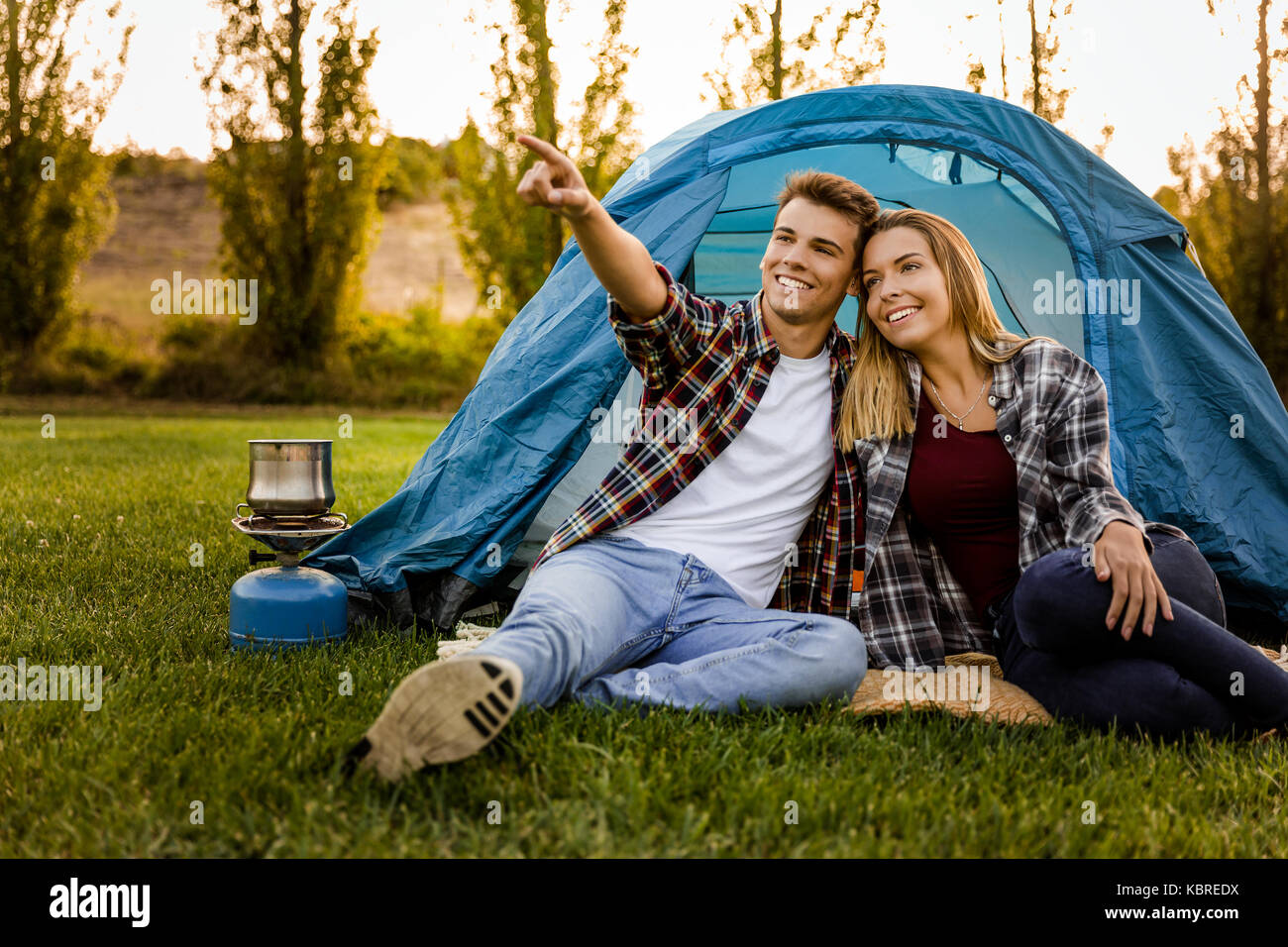 Captura de una feliz pareja acampar en la naturaleza y apuntando a un