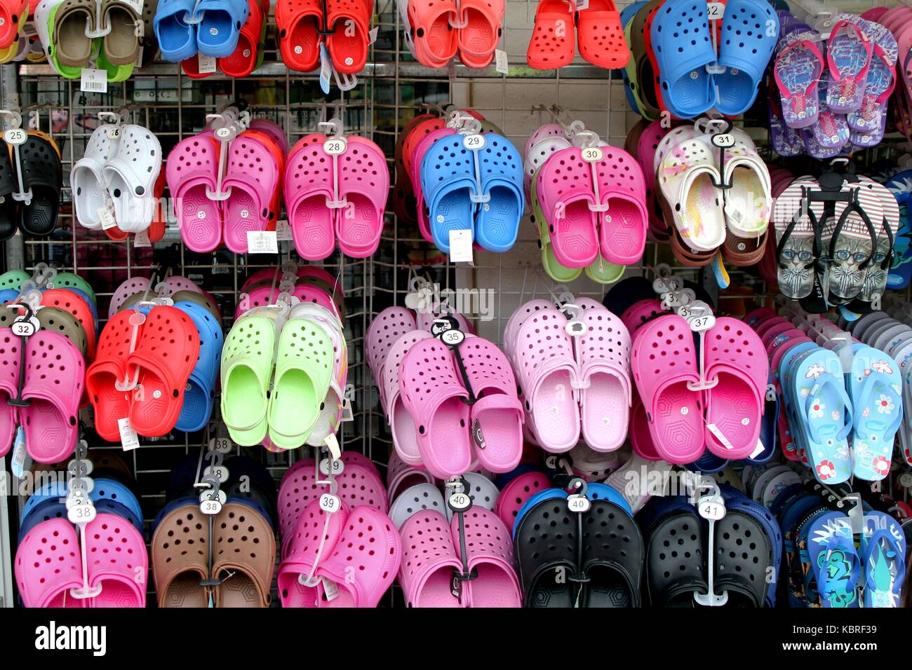 Rack con un montón de pares de sandalias de goma suave para niños o 'crocs'  en diversos rosa, azul, verde y negro los colores Fotografía de stock -  Alamy