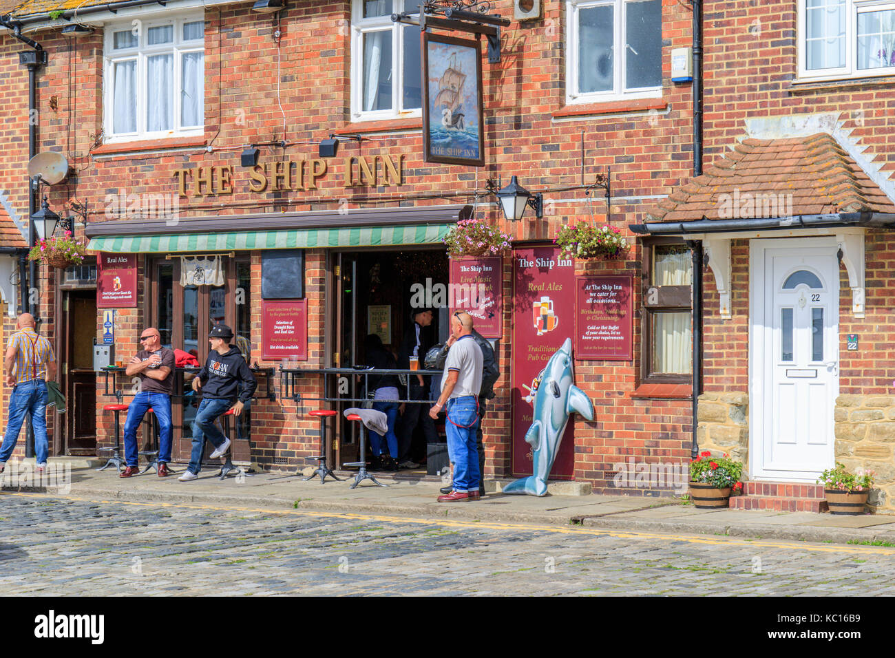 La gente disfruta de una bebida al aire libre en un pub al lado del muelle en Folkestone Kent. REINO UNIDO Foto de stock