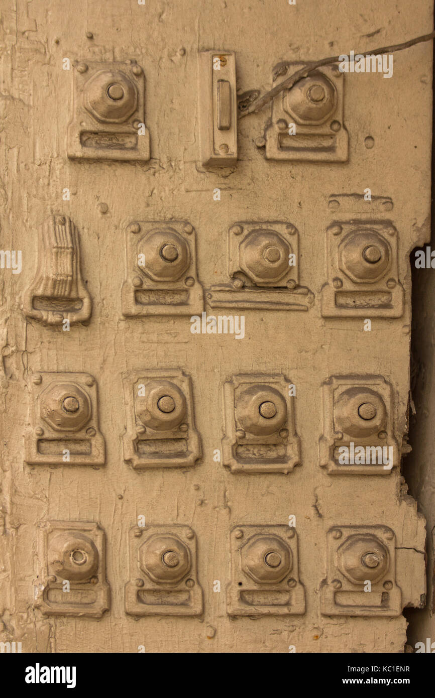 Cuatro filas de timbres alineadas a lo largo de este marco de puerta de  madera en el barrio francés de Nueva Orleans, Luisiana. Todos pintados del  mismo color buff Fotografía de stock -