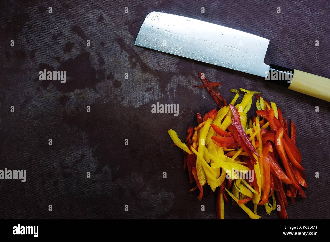 Tabla con cuchillo y trozados pimienta. vista superior del equipo de cocina y hortalizas frescas Foto de stock