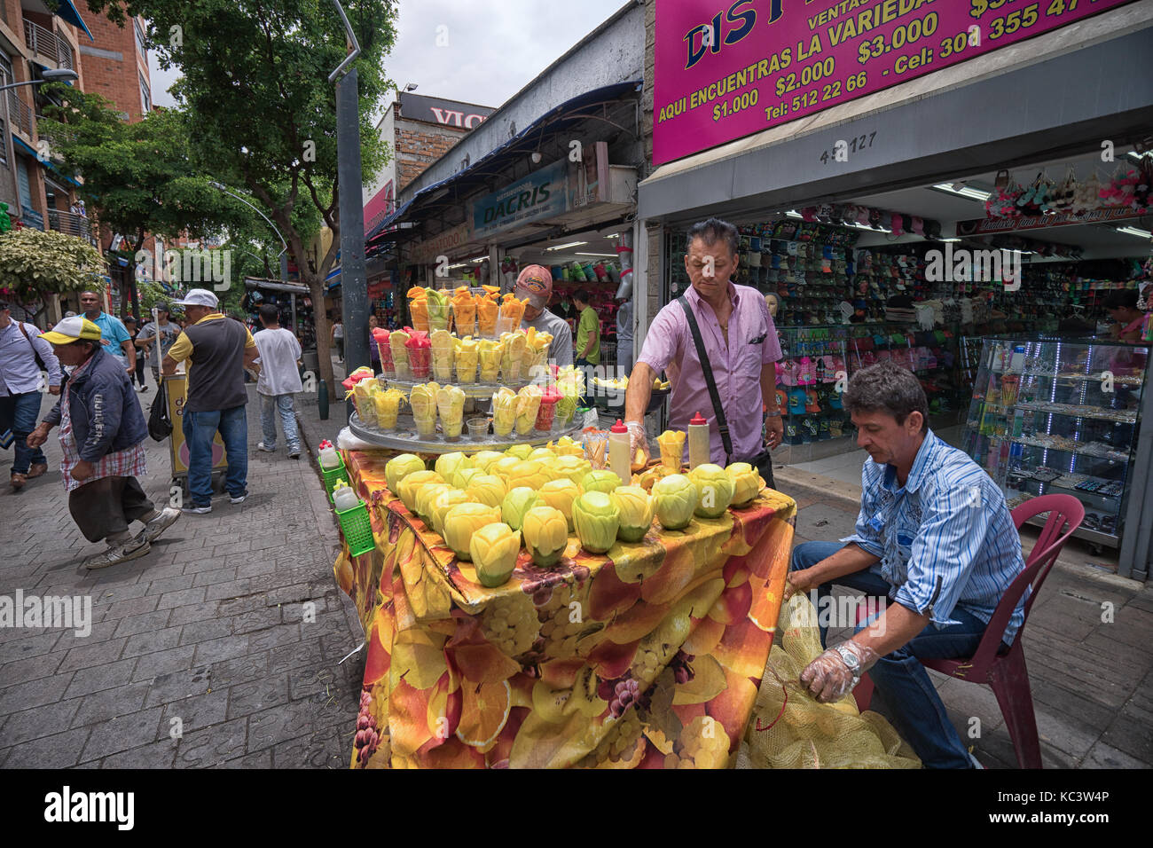 Septiembre 26, 2017 Medellín, Colombia: el proveedor vendiendo frutas frescas cortadas en cups como refrescos en el centro de la ciudad Foto de stock