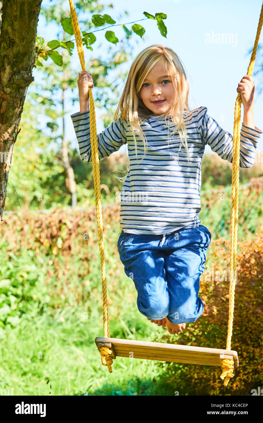 Parque infantil con columpio para bebés y deslice cerca de casas Fotografía  de stock - Alamy