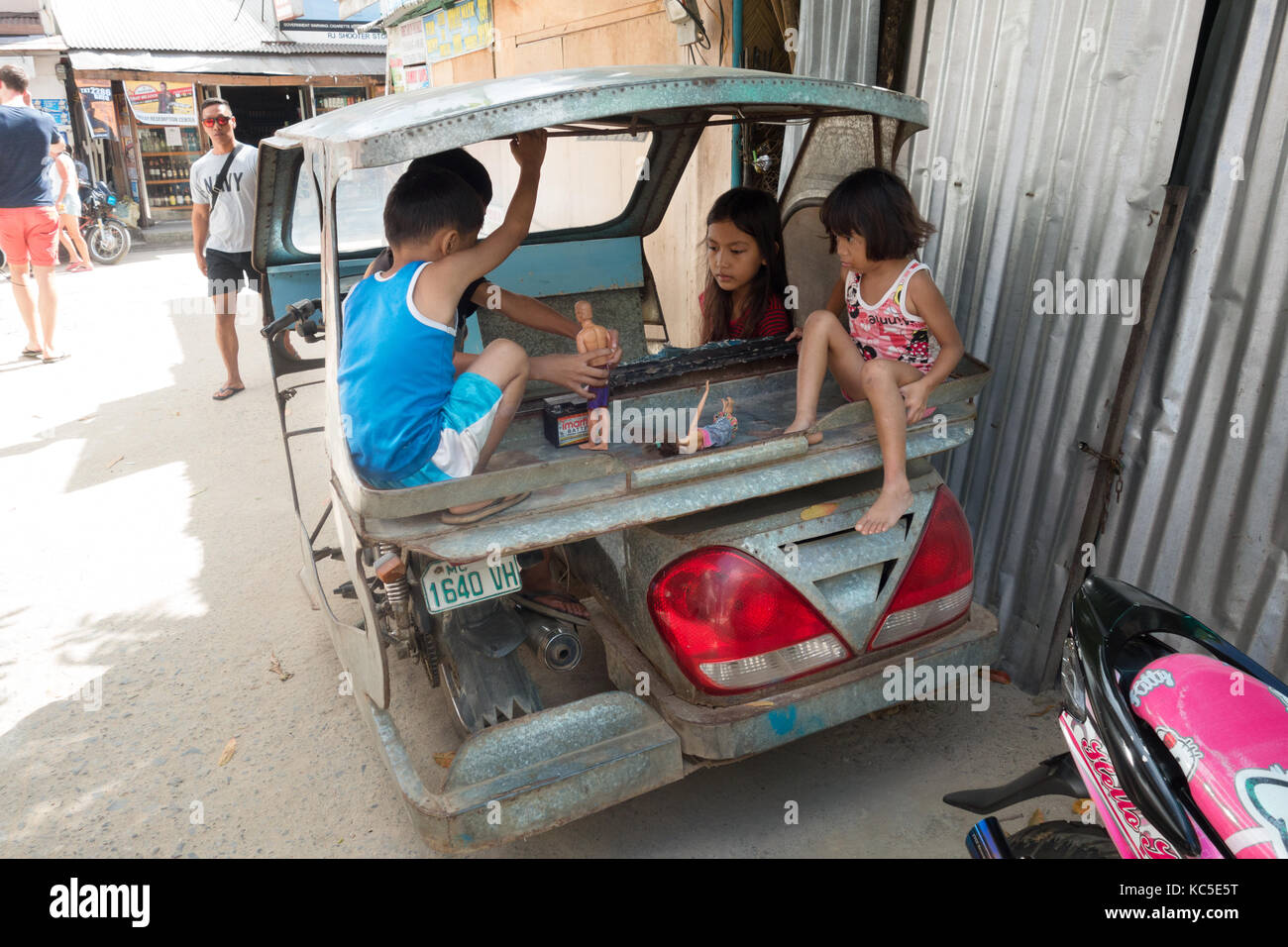 Filipinas niños jugando con muñecas en la parte de atrás de un taxi, en