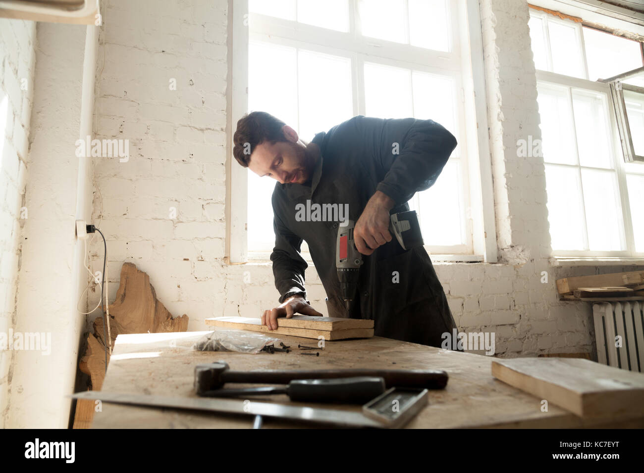 Joven carpintero haciendo carpintería en carpintería Foto de stock