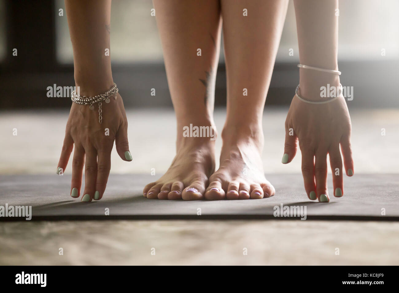 Cerca de manos femeninas tocando la estera del yoga Foto de stock