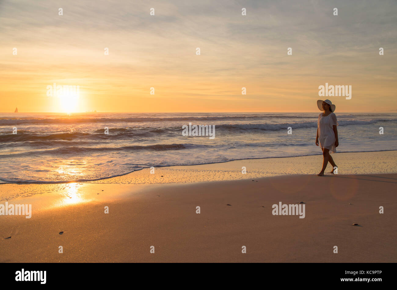 Mujer en la playa al anochecer milnerton, Ciudad del Cabo, Western Cape, Sudáfrica Foto de stock