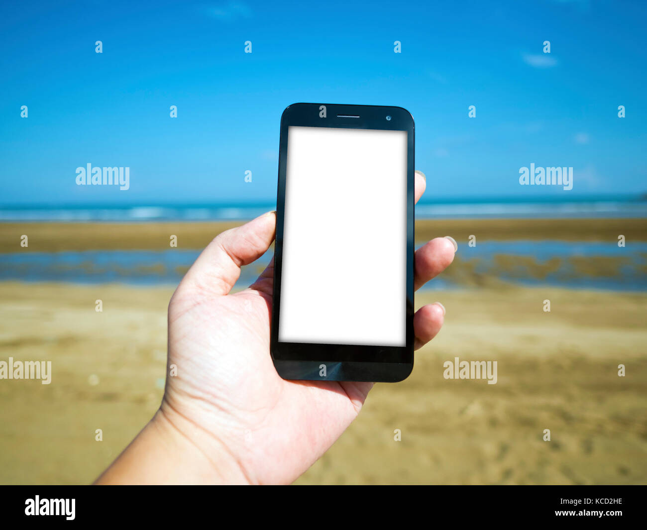 Teléfono inteligente a mano en verano en la playa Foto de stock