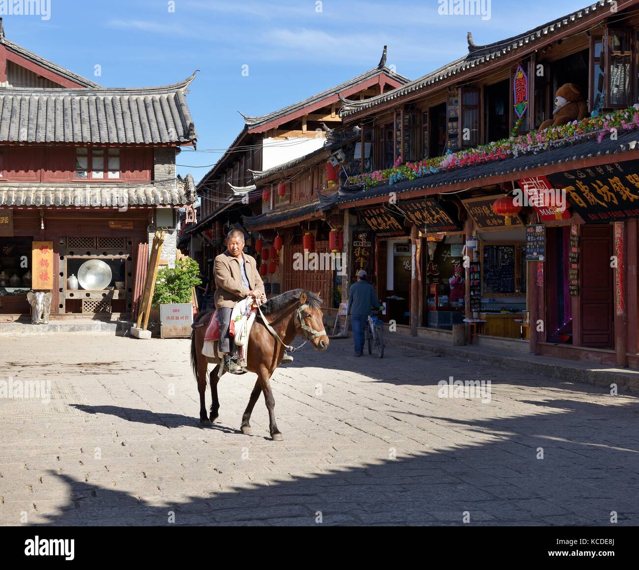 La ciudad vieja de Shuhe, sitio del patrimonio mundial, en la provincia de Yunnan, China. Pueblo étnico Naxi caballo y antigua cultura comercial comerciante sitio calle escena en Lijiang Foto de stock