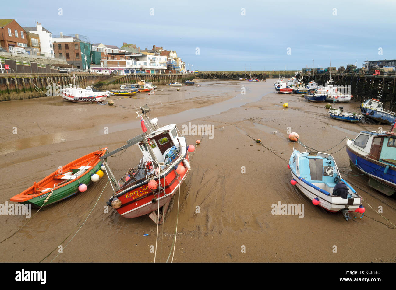 Varios botes pequeños tumbado en la arena en Bridlington Harbour en la marea baja. Bridlington, East Yorkshire. De enero. Foto de stock