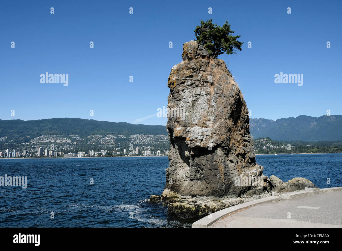 Siwash Rock, un afloramiento de roca famoso conocido por su forma de piña, que se asienta en el lado de agua de Stanley Park en Vancouver, British Columbia, Ca Foto de stock