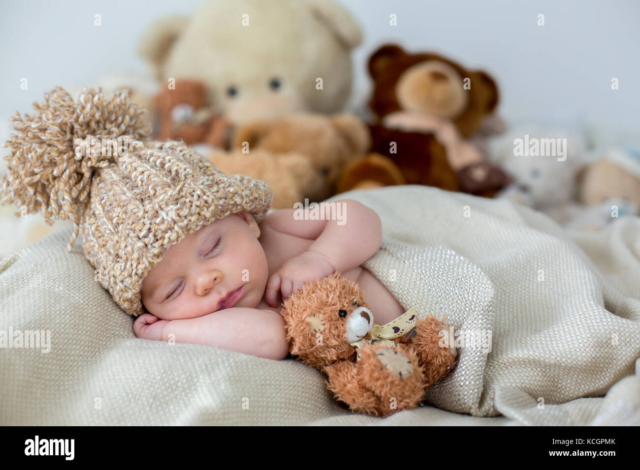 Pequeño bebé recién nacido niño, durmiendo con osito de peluche en casa en  la cama, descansando con juguete infantil Fotografía de stock - Alamy