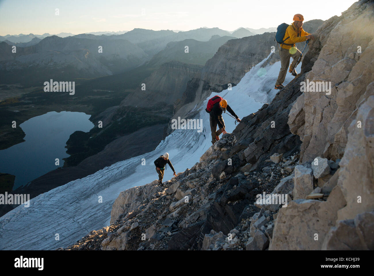 Tres hombres escaladores ascendiendo el North Ridge del Monte Assiniboine, British Columbia Foto de stock