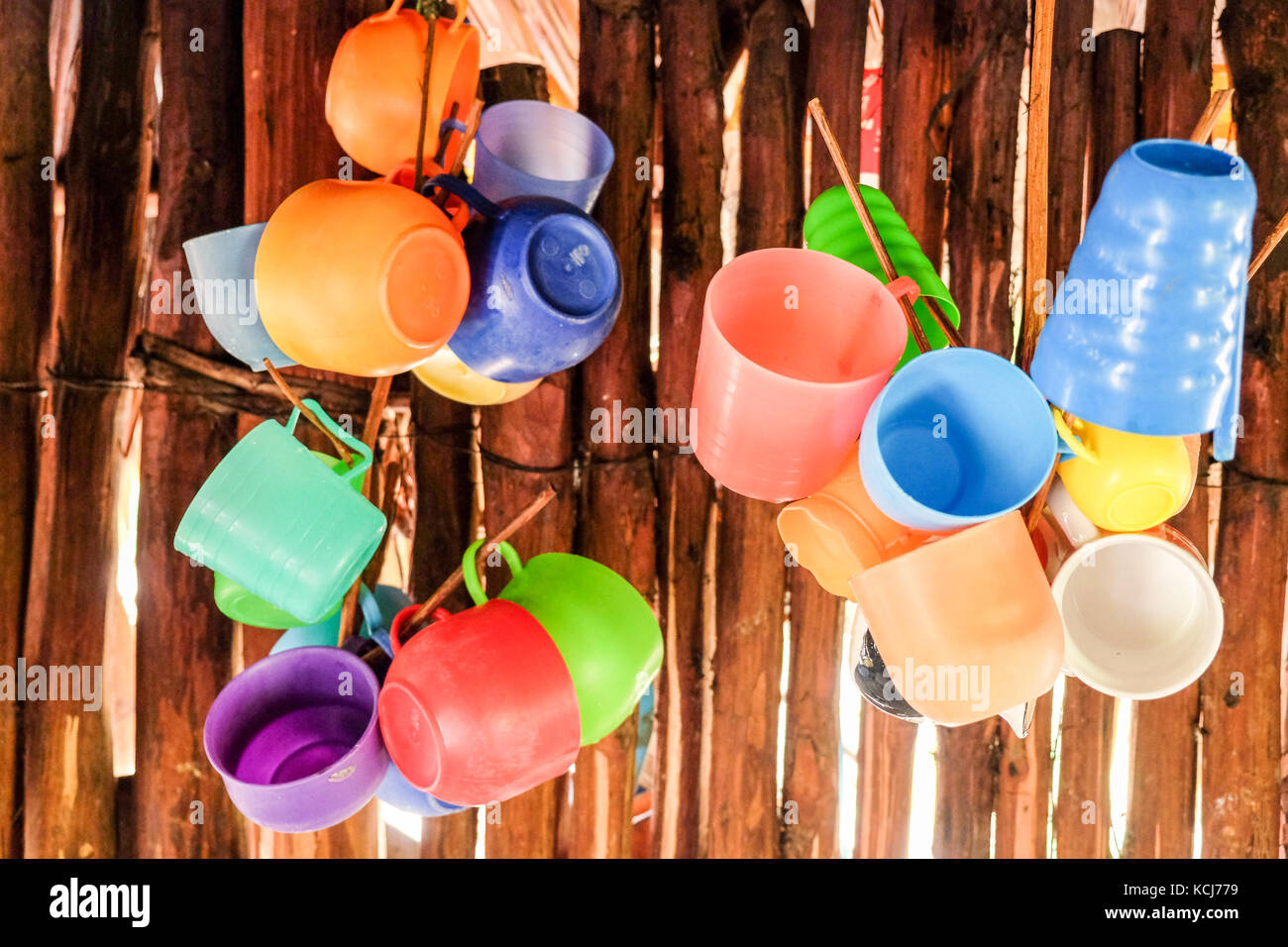 Vasos de plástico multicolor colgando en la pared de la cabaña de madera en  México Fotografía de stock - Alamy