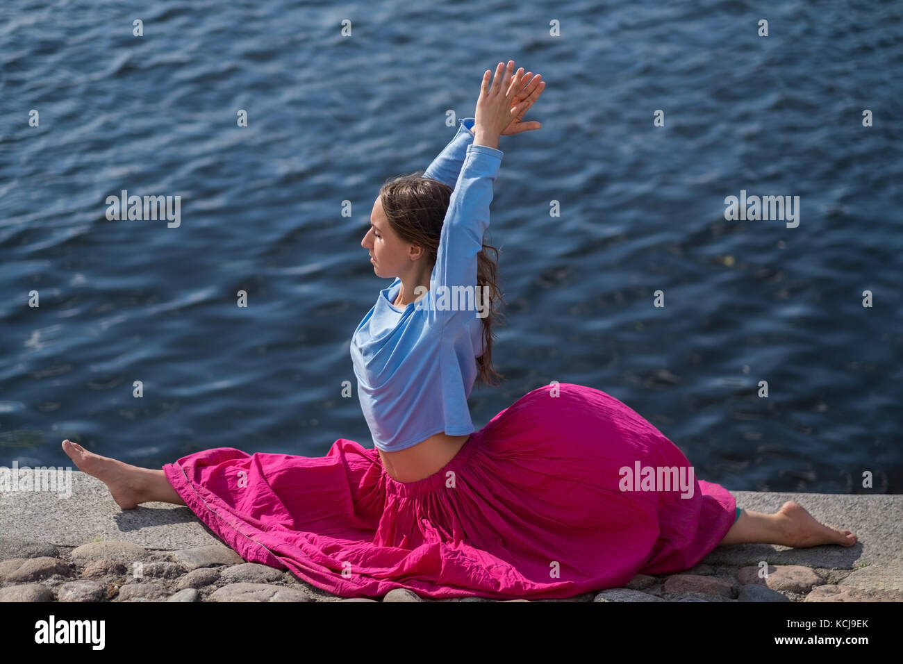 Colocar deportivo mujer caucásica haciendo asanas hanumanasana plantean la postura en la naturaleza. Foto de stock