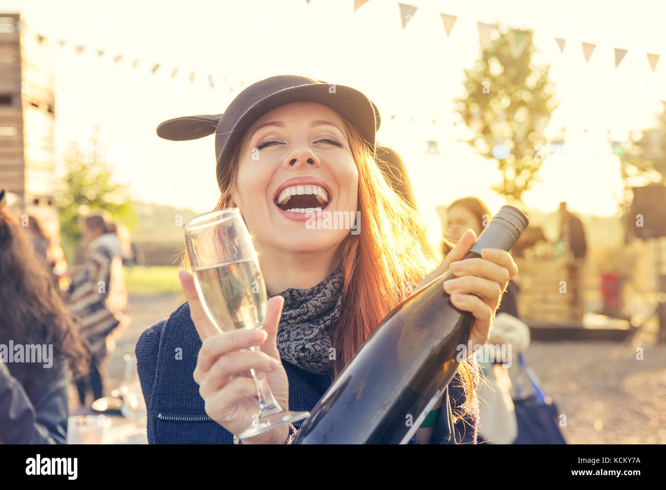 Mujer alegre y bebiendo vino a divertirse al aire libre Foto de stock