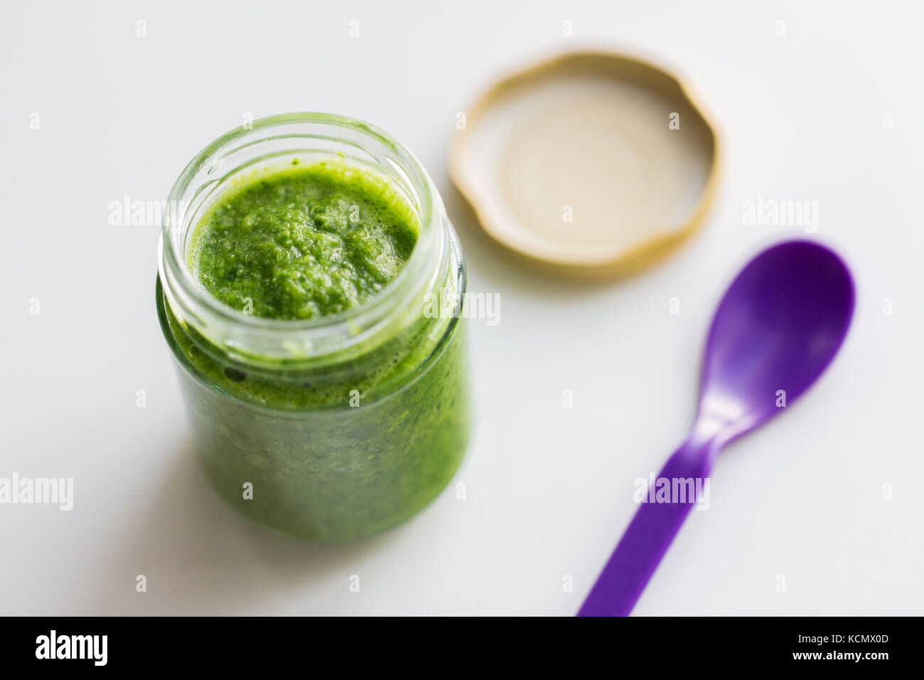 Tarro de puré de verduras o alimentos para bebé y cuchara Foto de stock