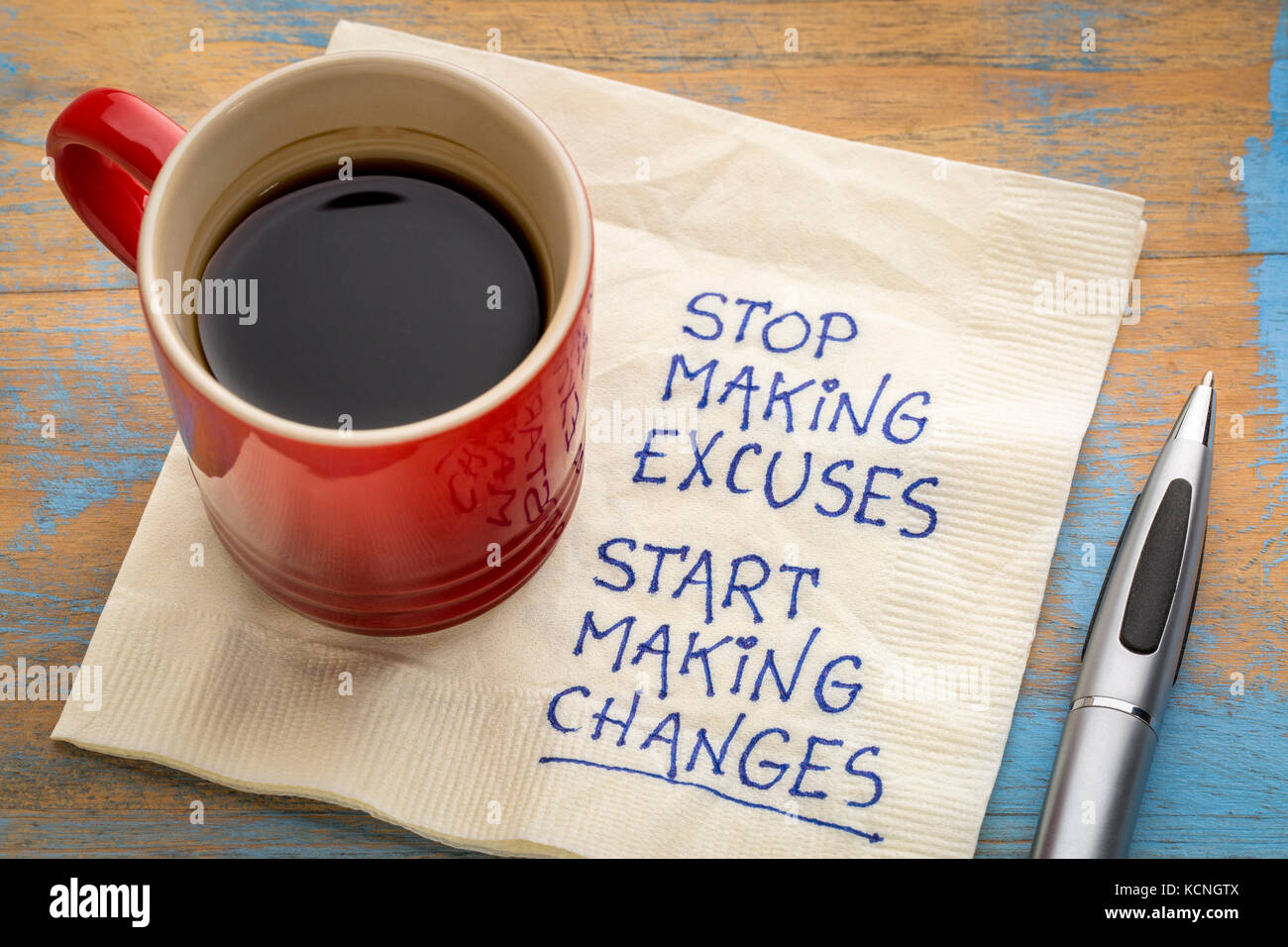 Dejar de hacer excusas, comenzar a realizar cambios de escritura en una servilleta con una taza de café Foto de stock