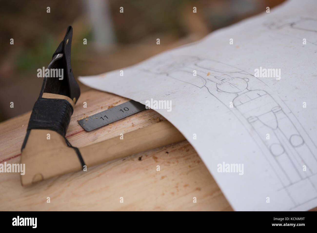Un adze utilizado para desbastar y un dibujo de Thunderbird y un hombre forman el comienzo de un polo que está siendo tallado por un carver de la primera nación local. Comox, Vancouver Island, British Columbia, canadá. Foto de stock