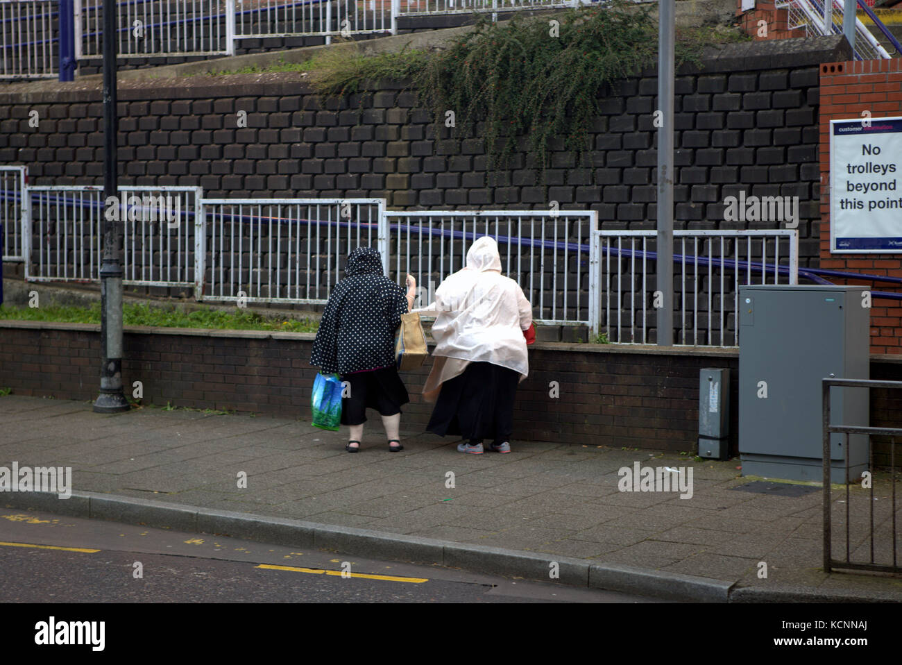 Dos grandes damas sobrepeso grasa compras insalubres y ventoso día caminando uk Foto de stock